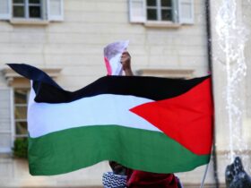 a person holding a flag in front of a building