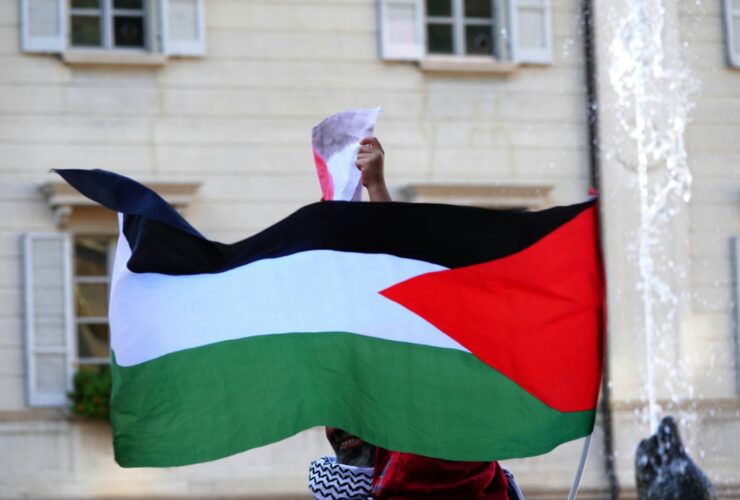 a person holding a flag in front of a building