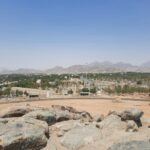 a rocky area with a city in the background