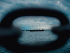 a view through a hole in a boat window of a sailboat on the water