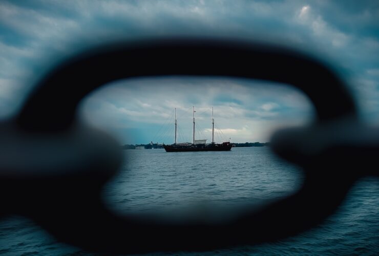 a view through a hole in a boat window of a sailboat on the water