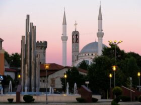 A mosque and fountain under a pink sunset.